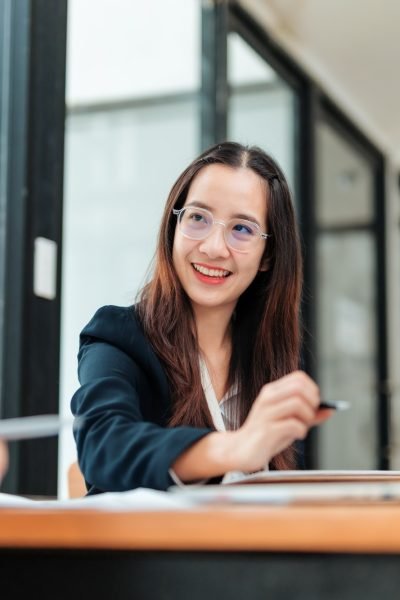 Businesswomen discussing work using laptop and documents in modern office